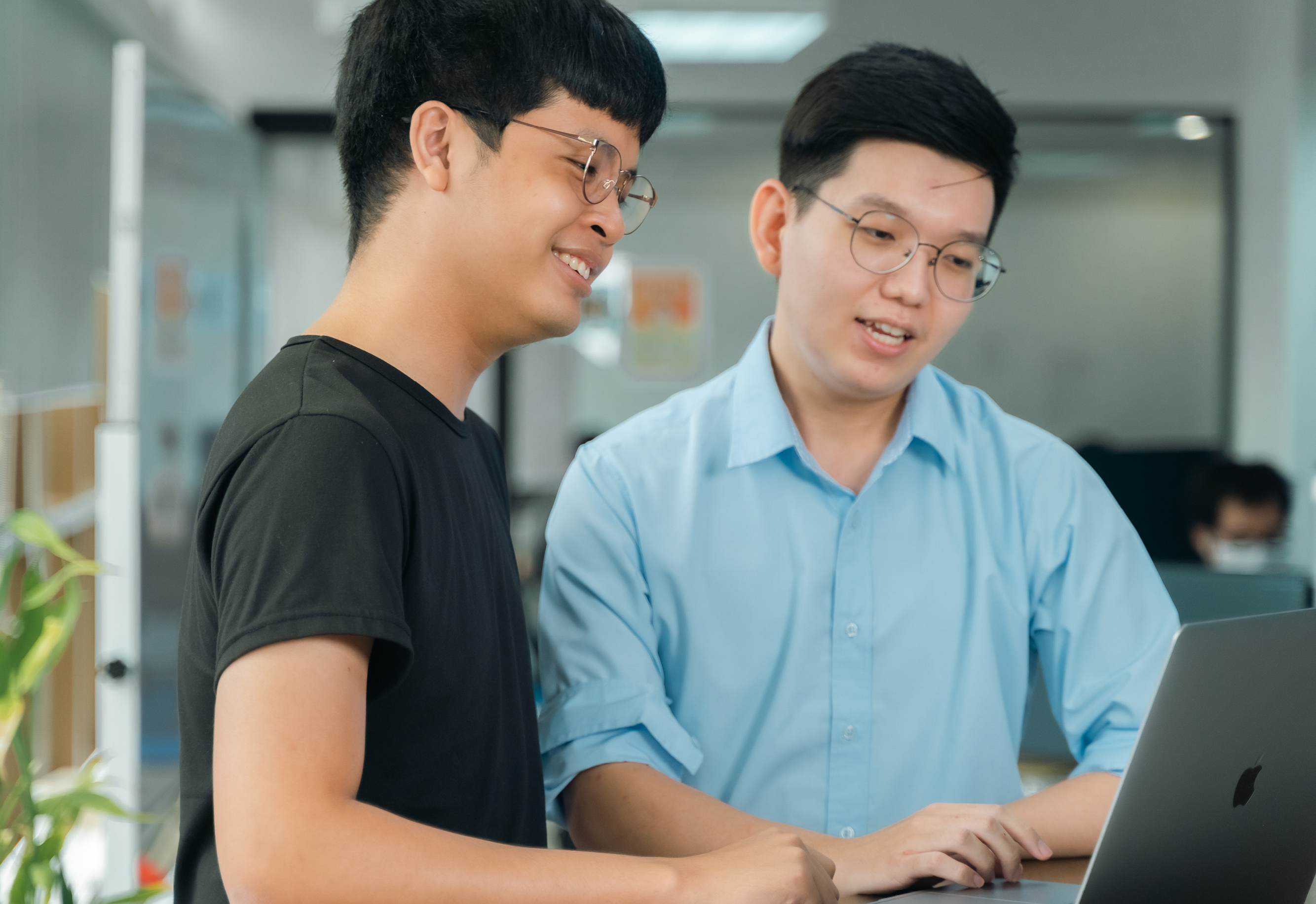 Two young men looking at a laptop screen