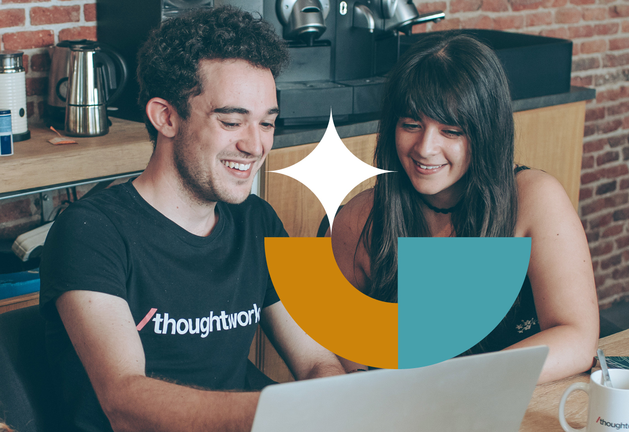 Two Thoughtworkers smiling at the computer