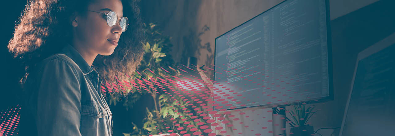 Woman coding on computer surrounded by colourful dot graphic/texture 