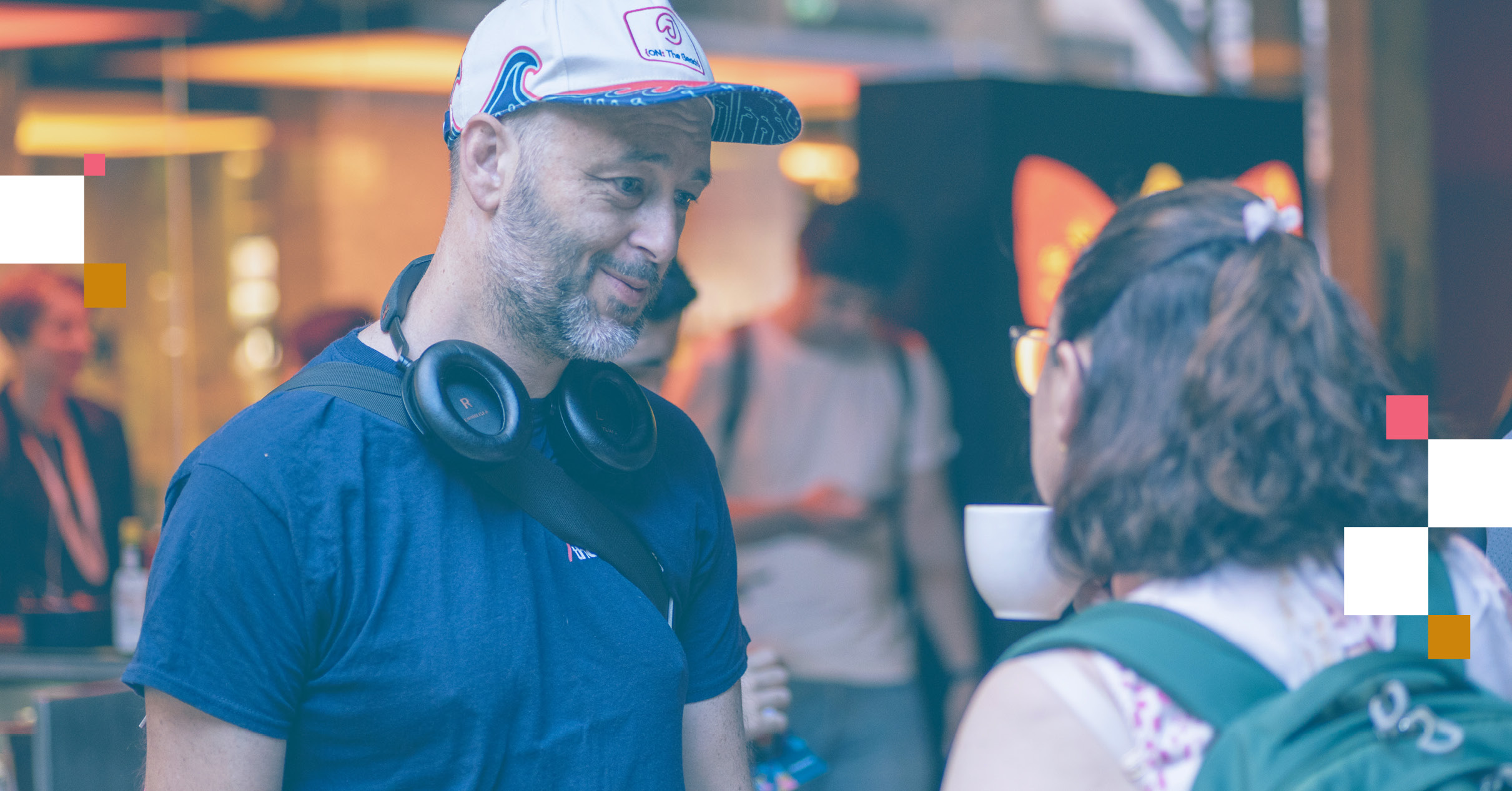 Image of two people talking, highlighting a Thoughtworker wearing a cap and a person with their back to the camera.