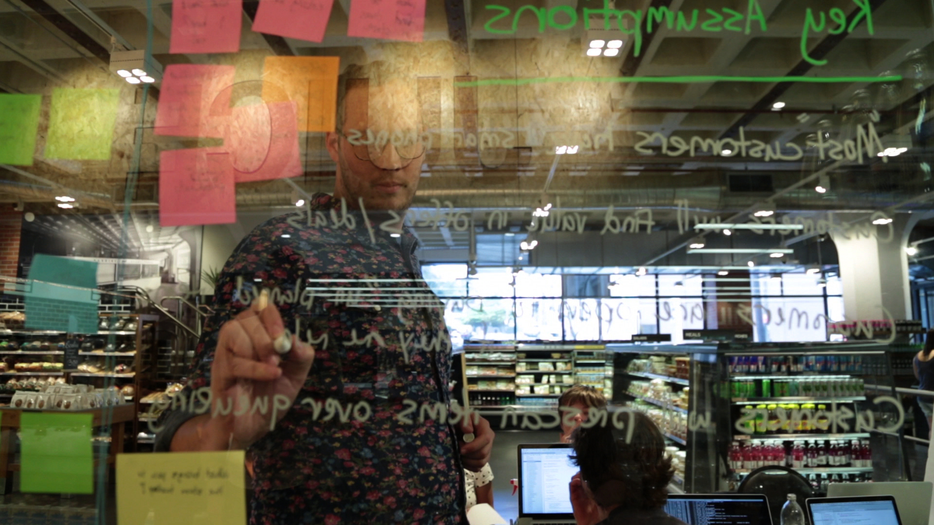 Lean Product Innovation Session in Progress man drawing on glass board product innovation ideation