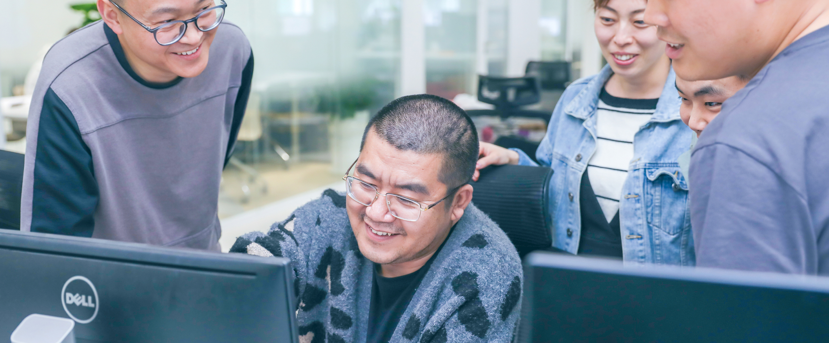 Photo of 5 Thoughtworkers gathered in an office, looking at a computer. Photo of 5 Thoughtworkers gathered in an office, looking at a computer.