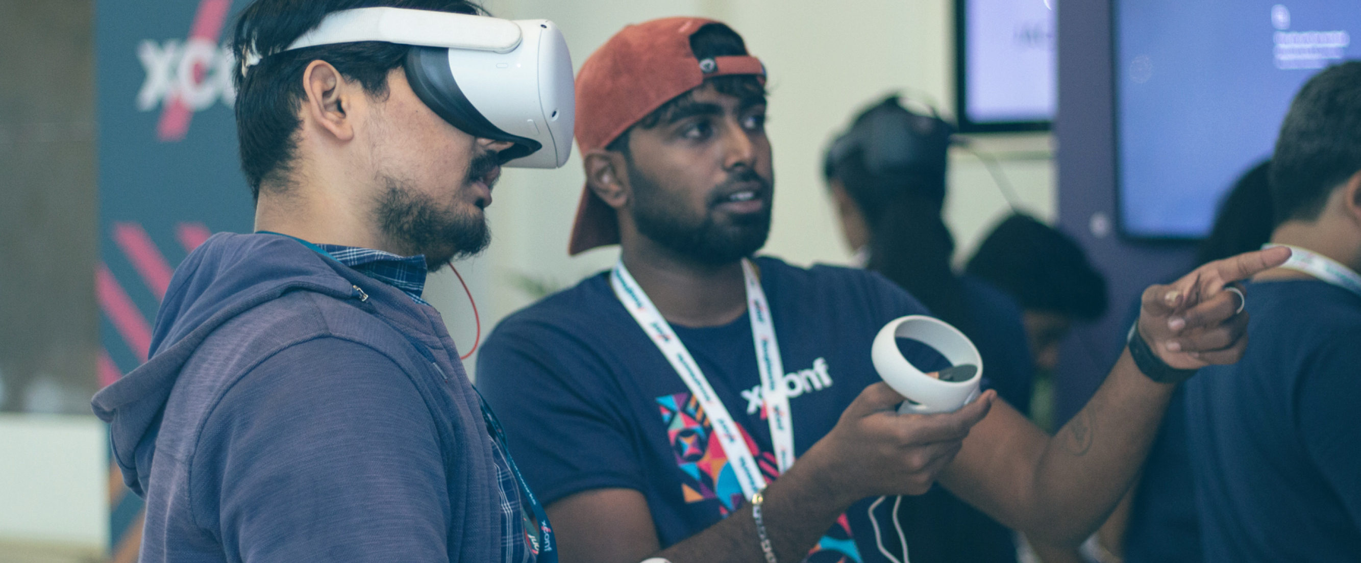 Photo of two men wearing virtual reality glasses at the XConf conference. Photo of two men wearing virtual reality glasses at the XConf conference.